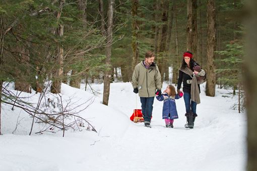 Family of three walking on a snowy trail